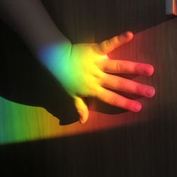 Close-up of hands against illuminated wall