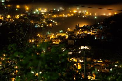 Illuminated cityscape against sky at night