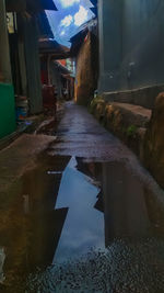 Reflection of building in puddle at night