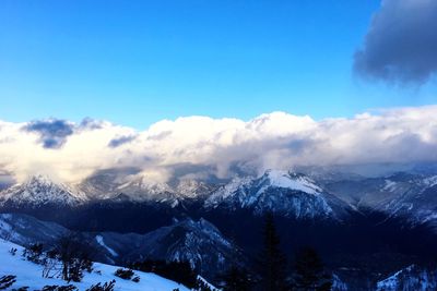 Scenic view of snowcapped mountains against blue sky