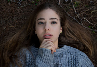 Portrait of young woman lying on field