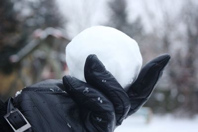 Person holding snow covered hand during winter