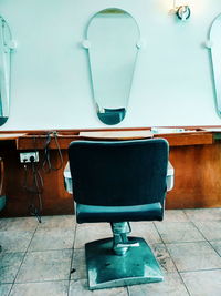 Empty chairs and table against wall