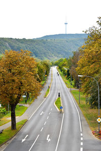 Road amidst trees against sky during autumn