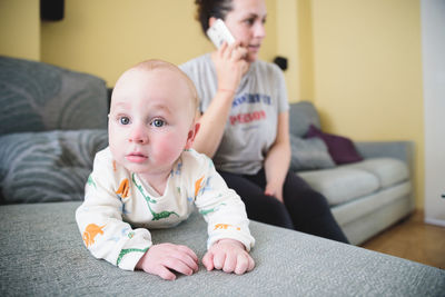 Portrait of cute boy sitting on sofa at home