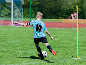 Full length of man running on soccer field