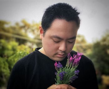 Portrait of teenage girl against purple flowering plants