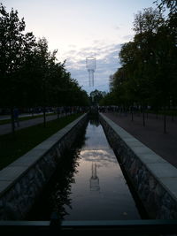 Canal amidst trees against sky