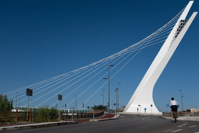 Low angle view of vehicles on road against clear blue sky