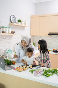 Rear view of woman preparing food at home