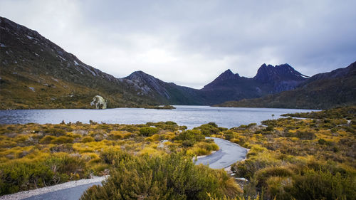 Scenic view of lake by mountains against sky