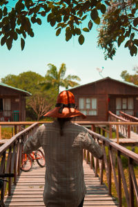 Man standing on footbridge against building