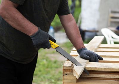 Midsection of man working on wood