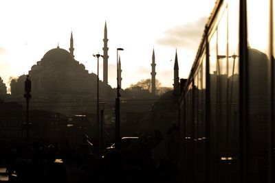 Mosque in city against sky