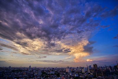 Panoramic view of buildings against cloudy sky