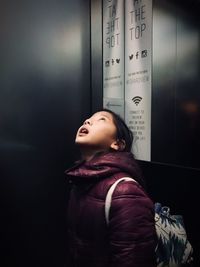 Girl looking up while standing in elevator