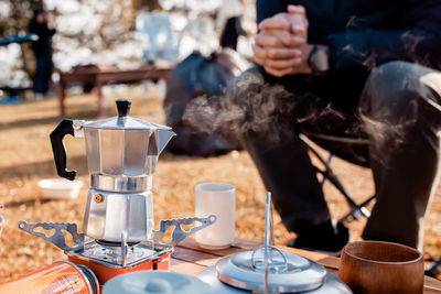 Man preparing coffee in a moka pot outdoor.