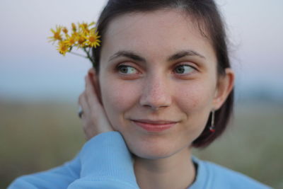 Close-up of smiling young woman looking away