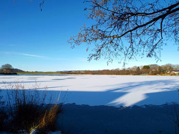 Scenic view of lake against sky during winter