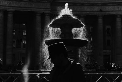 Silhouette man standing against window of building