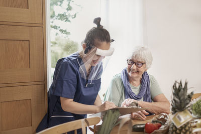 Home carer helping senior woman at home