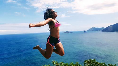 Young woman in sea against sky