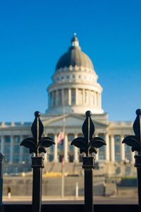 Capture of utah state capitol blurred in background with iron fence in foreground. 