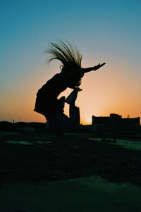 Silhouette woman jumping against clear sky during sunset