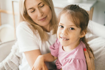 A little girl hugs her mother. granddaughter hugs her grandmother.