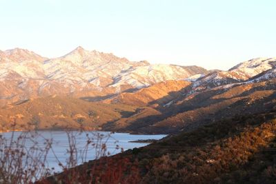 Scenic view of lake and mountains against clear sky