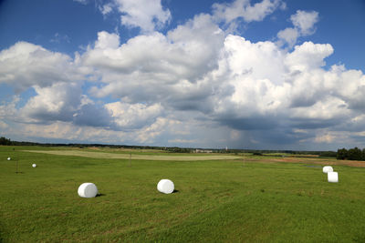 Scenic view of field against cloudy sky