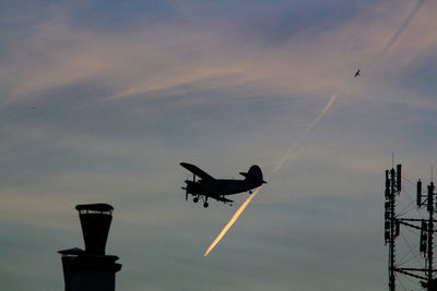 Low angle view of silhouette airplane against sky during sunset