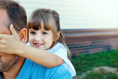 Portrait of cute girl playing with father outdoors