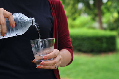 Midsection of woman drinking glass
