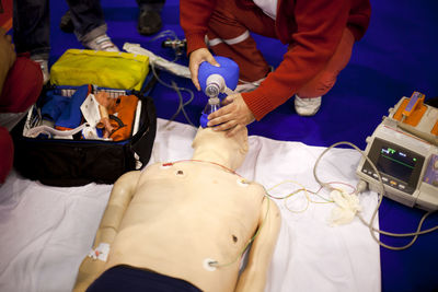 High angle view of healthcare worker practicing mechanical ventilation on cpr dummy