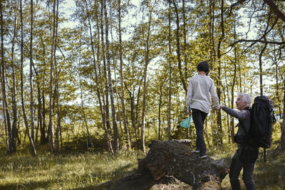 Rear view of people walking in forest