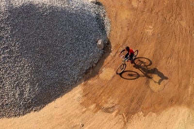 High angle view of person riding bicycle on sand