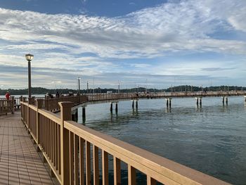 Bridge over river against sky in city