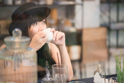 Portrait of young woman drinking coffee at cafe