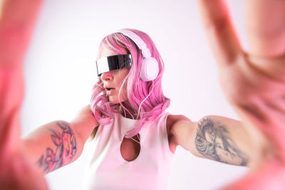 Young woman listening music against white background