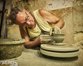 Potter in workshop working on vase