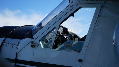 Close-up of airplane window against sky