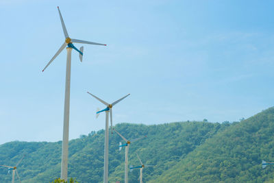 Wind turbines on landscape against sky