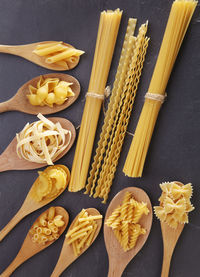 Close-up of raw pasta and wooden spoon on table