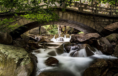 Stream flowing below bridge