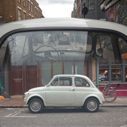 Car on street against buildings in city