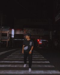 Full length of man standing on illuminated city at night