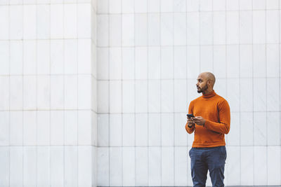 Side view of man standing against wall