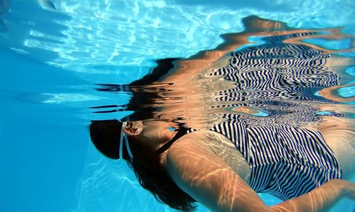 Side view of young woman swimming in pool