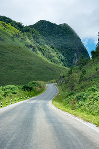 Road by mountain against sky